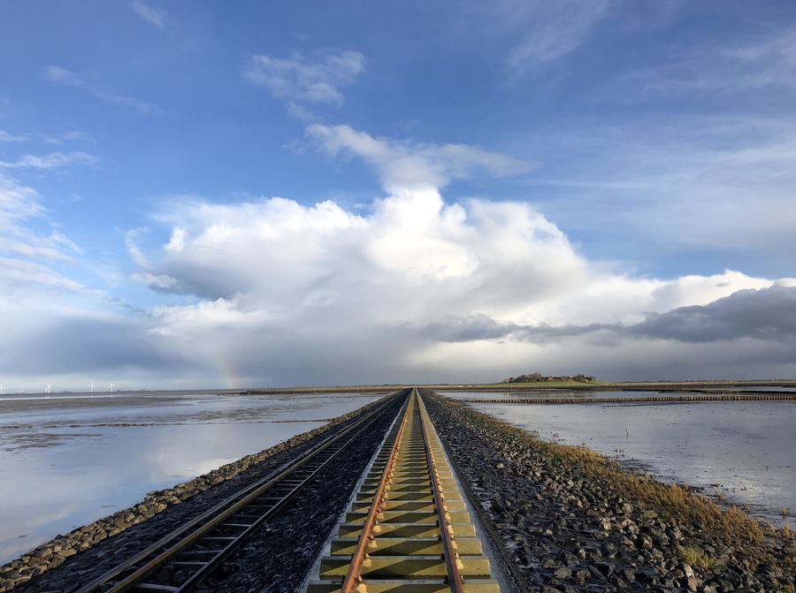 Halligdamm Langeness mit Regenbogen – Anreise per Lore